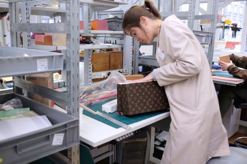 An authenticator inspecting a handbag